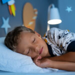 Little boy sleeping in his galaxy bedroom