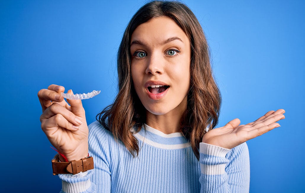 Young woman holding her clear aligners
