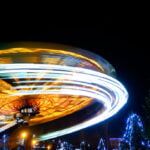 Carousel, tilt-a-whirl in motion, with extended exposure. At night in the amusement park.