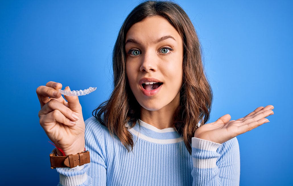 teenager holding her clear aligners